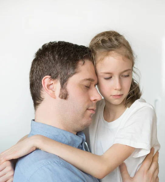 Trauriges kleines Mädchen umarmt ihren Vater. — Stockfoto