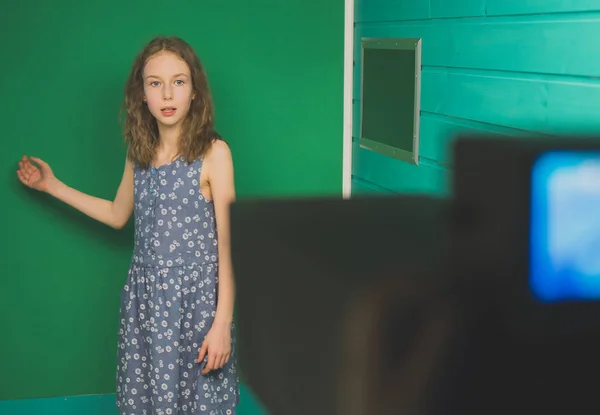 天气预报。小女孩站在相机前的绿色屏幕上. — 图库照片