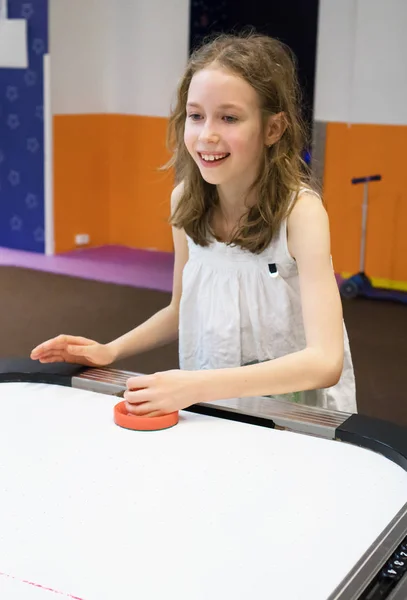 Niedliches kleines Mädchen spielt Tischhockey. — Stockfoto