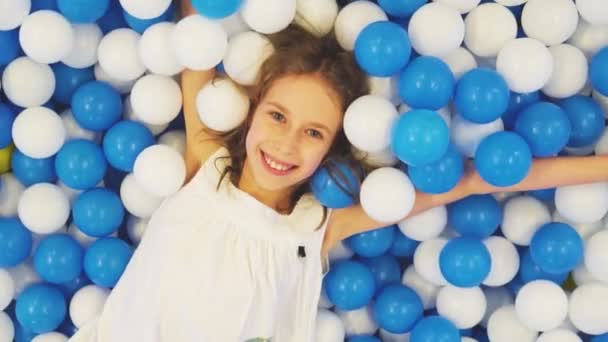 Ładny Uśmiechający Się Mała Dziewczynka Leżącego Plastikowe Kulki Pokoju Zabaw — Wideo stockowe
