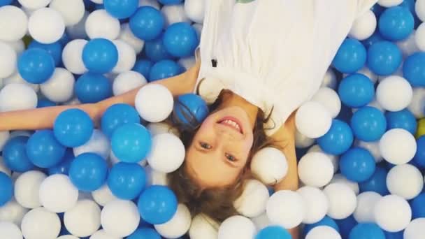 Schattig Lachende Klein Meisje Liggend Plastic Ballen Speelkamer — Stockvideo
