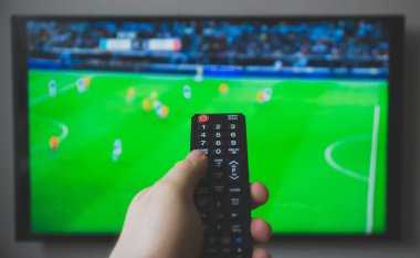 TV uzaktan kumanda tutan erkek el. Futbol oyunu.