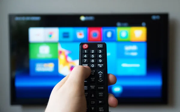 Męskiej ręki trzymającej pilota telewizora. Smart Tv. — Zdjęcie stockowe