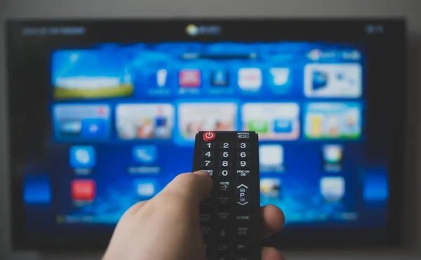 Male hand holding TV remote control. Smart TV. — Stock Photo, Image