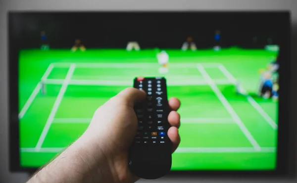 Male hand holding TV remote control. Tennis tournament. — Stock Photo, Image