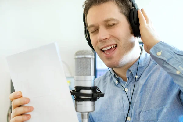 Hombre guapo grabando una canción en un estudio de grabación. — Foto de Stock