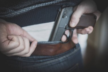 adam silah arkasından gizleme.