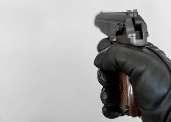 Hand in leather glove holding gun and aiming. — Stock Photo, Image