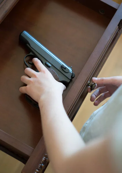 Dziecko znaleziono pistolet do szuflady w domu. — Zdjęcie stockowe