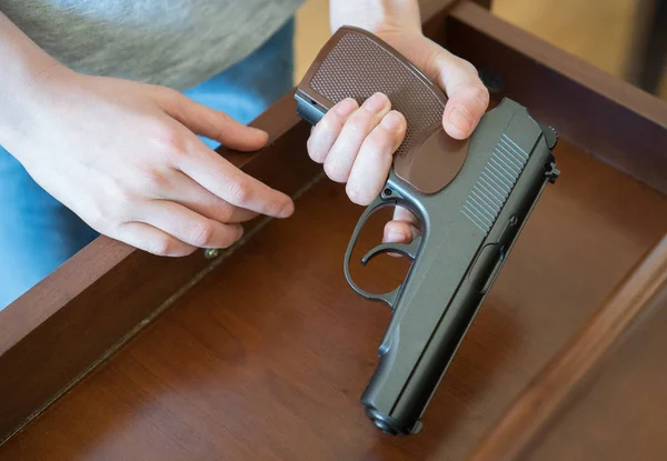 Child found pistol in drawer at home. — Stock Photo, Image