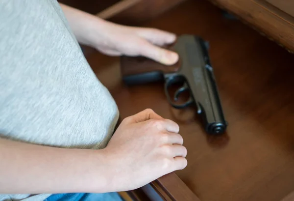 Criança encontrou pistola na gaveta em casa . — Fotografia de Stock
