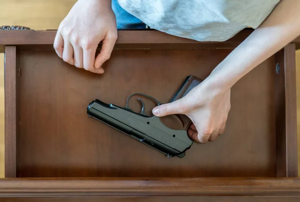 Kind gevonden pistool in lade thuis. — Stockfoto