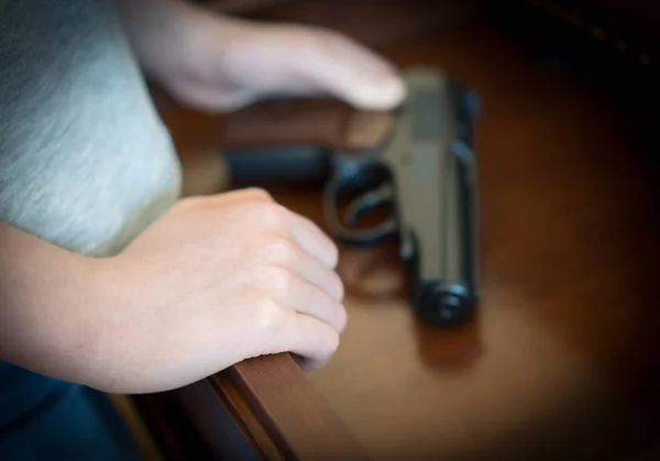 Criança encontrou pistola na gaveta em casa . — Fotografia de Stock