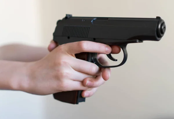 Mão de criança segurando uma arma e apontando . — Fotografia de Stock