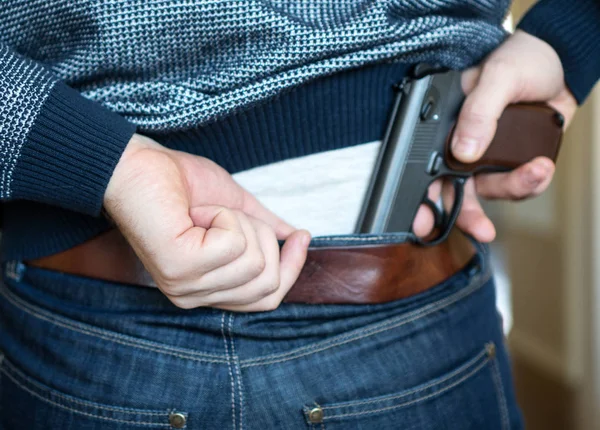 Hombre escondiendo arma detrás de su espalda . — Foto de Stock