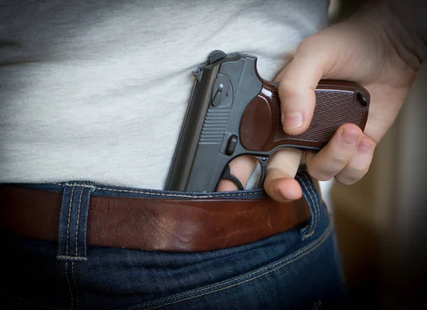 Muž schovává zbraň za jeho zády. — Stock fotografie