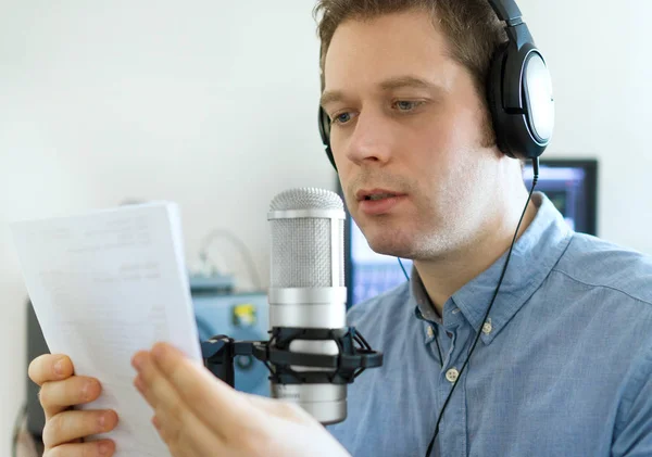 Stilig man spelar in en annons på radiostationen. — Stockfoto