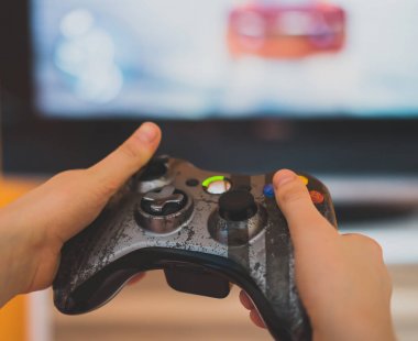Bir joystick ile bilgisayar oyunları oynayan çocuk.