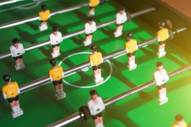 Sarı ve beyaz oyuncu ile masa futbol oyunu.
