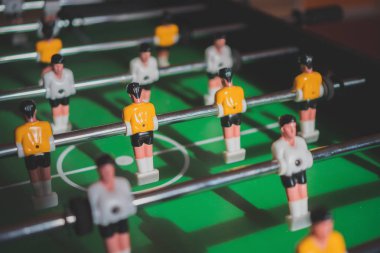 Sarı ve beyaz oyuncu ile masa futbol oyunu.