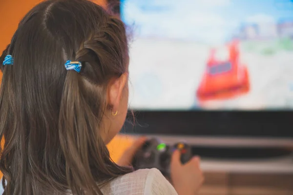 Liten flicka spela datorspel med en joystick. — Stockfoto