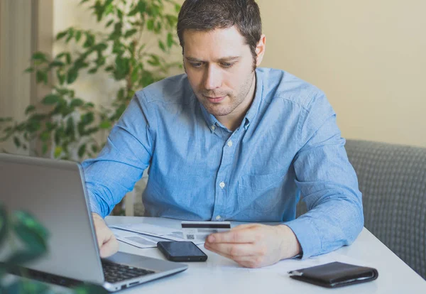 Hombre guapo pagando con tarjeta de crédito en la tienda de Internet . — Foto de Stock