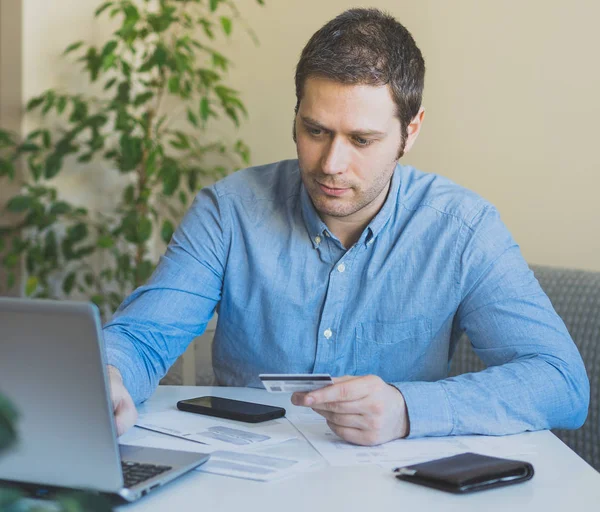 Schöner Mann bezahlt mit Kreditkarte in Internet-Shop. — Stockfoto