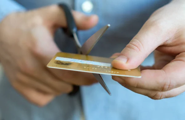 Hombre de corte de oro tarjeta de crédito con tijeras. — Foto de Stock