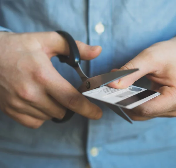 Homem cortando cartão de crédito com tesoura. — Fotografia de Stock