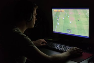 Adam geceleri bilgisayar futbol oyunu oynamak kulaklık.