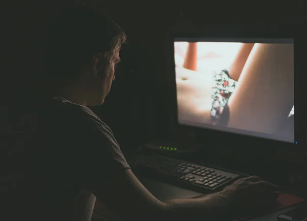 Mann schaut nachts Erotikfilm am Computer. — Stockfoto