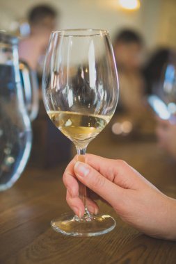 Bardak beyaz şarap tutan kadın. Şarap tadım.