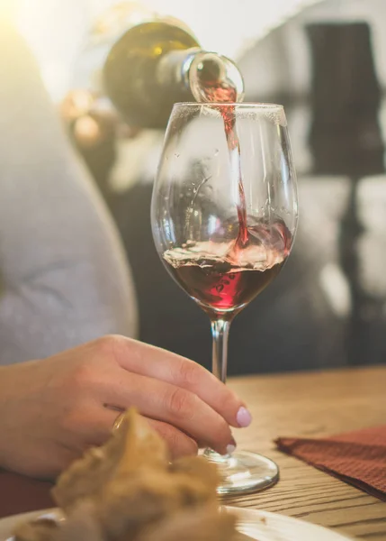 Versare il vino rosso dalla bottiglia nel bicchiere. Degustazione vini . — Foto Stock