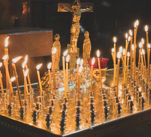 Viele Kerzen leuchten auf Tisch in orthodoxer Kirche. — Stockfoto