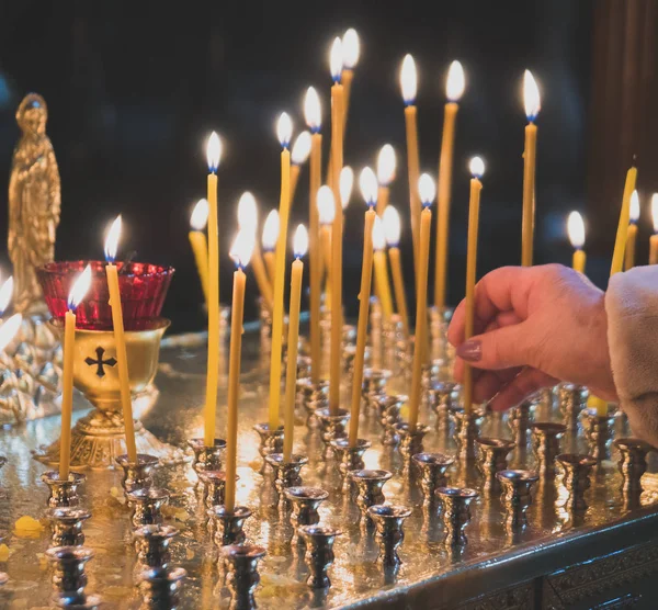 Viele Kerzen leuchten auf Tisch in orthodoxer Kirche. — Stockfoto