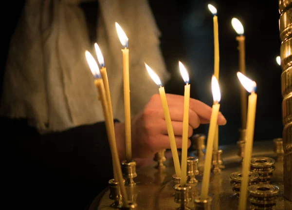 A mulher acende a vela na igreja ortodoxa russa. Close-up . — Fotografia de Stock