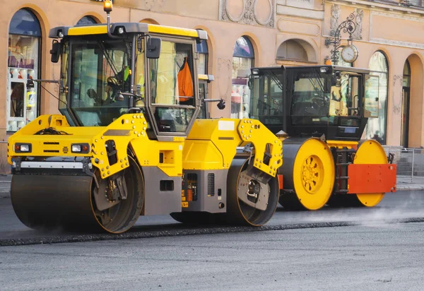 Road re-construction. Road rollers stacking hot asphalt.