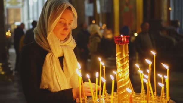 Женщина Зажигает Свечу Русской Православной Церкви — стоковое видео