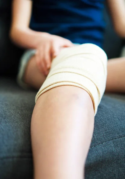 Child knee with gauze bandage. Close-up view. — Stock Photo, Image