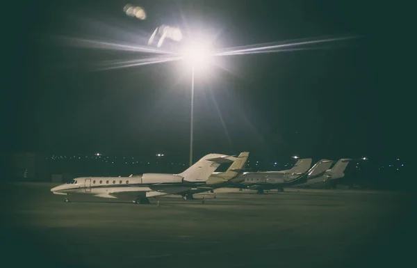 Private passenger planes near hangar at night airport. — Stock Photo, Image