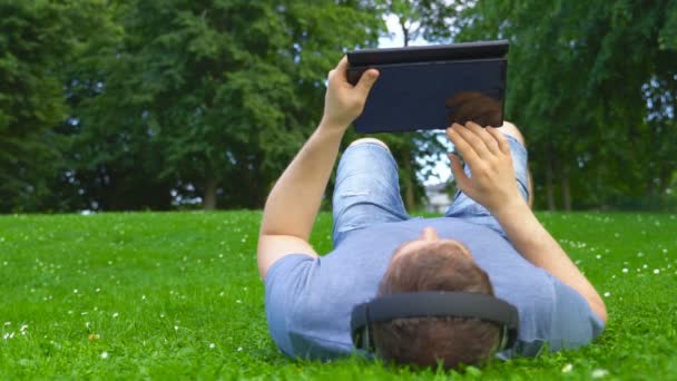 Man Lying Grass Tablet Summertime — Stock Video