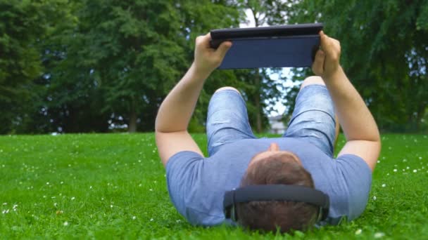 Mann Liegt Sommer Mit Tablet Gras — Stockvideo