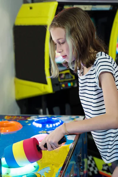 Bambina che gioca martello arcade macchina da gioco nel parco a tema . — Foto Stock