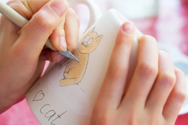 Kind schildert een mok in een pottenbakkerij. — Stockfoto