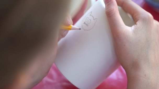 Enfant peint une tasse dans un atelier de poterie . — Video