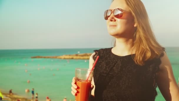 Frau mit Cocktail und Entspannung am Meer. — Stockvideo