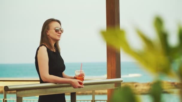 Mulher com coquetel e relaxante perto do mar . — Vídeo de Stock