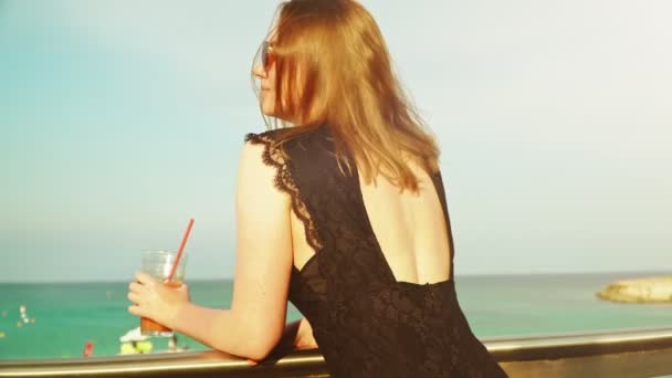 Frau mit Cocktail und Entspannung am Meer. — Stockvideo