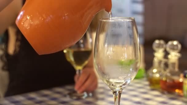 Vrouw giet witte wijn uit pot. — Stockvideo