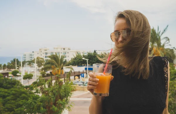 Bella donna in abito nero con vetro di succo di frutta in vacanza . — Foto Stock